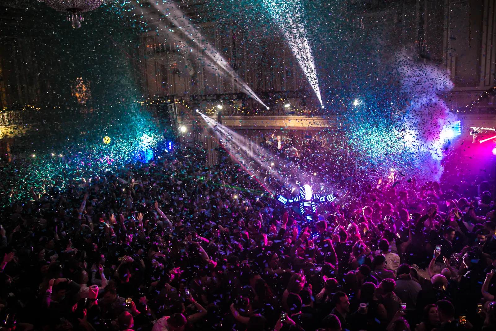 Big Night New Year’s Eve gala: guests dance under falling confetti, lasers and chandeliers in a packed ballroom