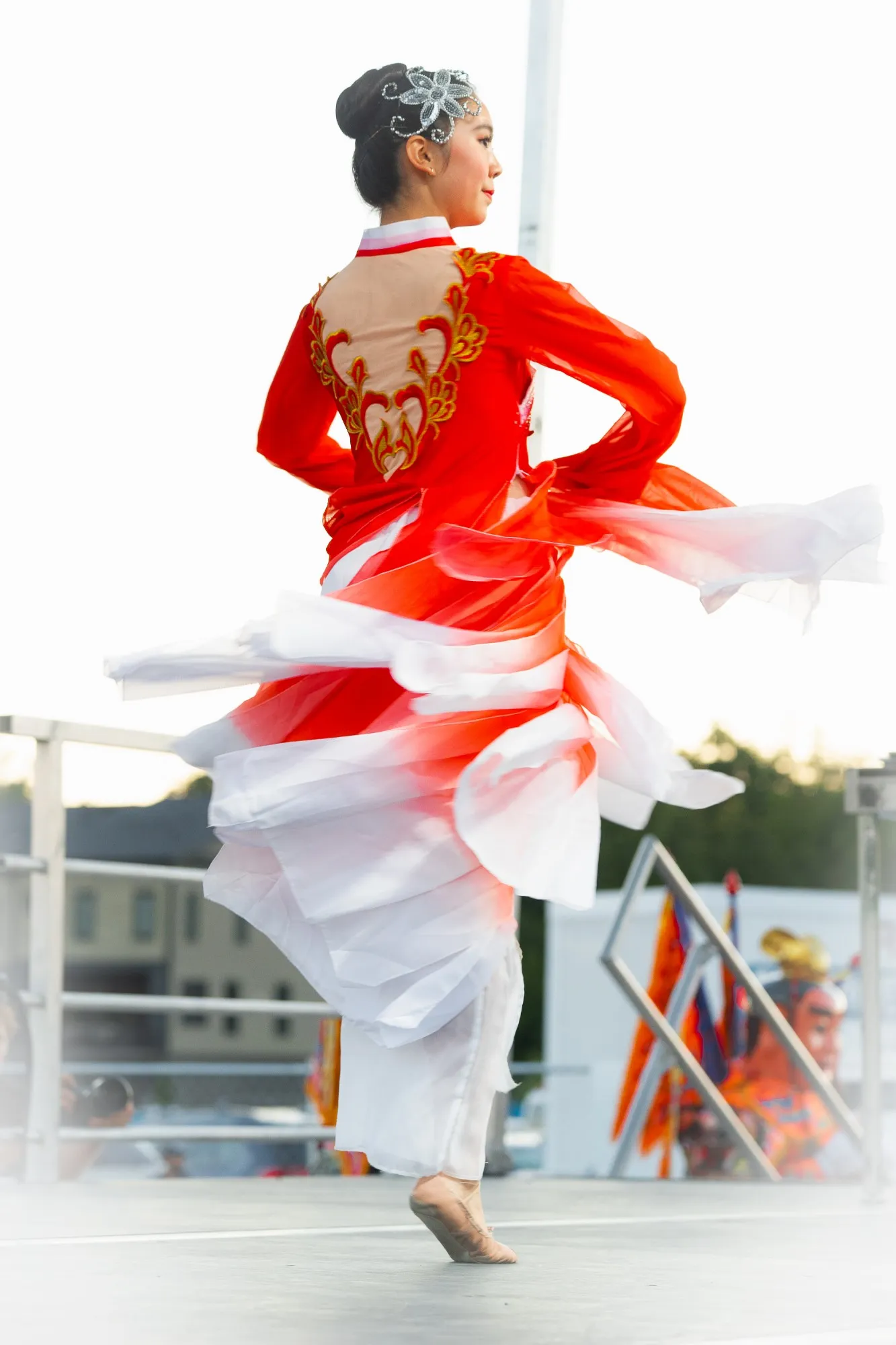US Asian Fest: a dancer in a red and white embroidered costume spins through a classical Chinese dance