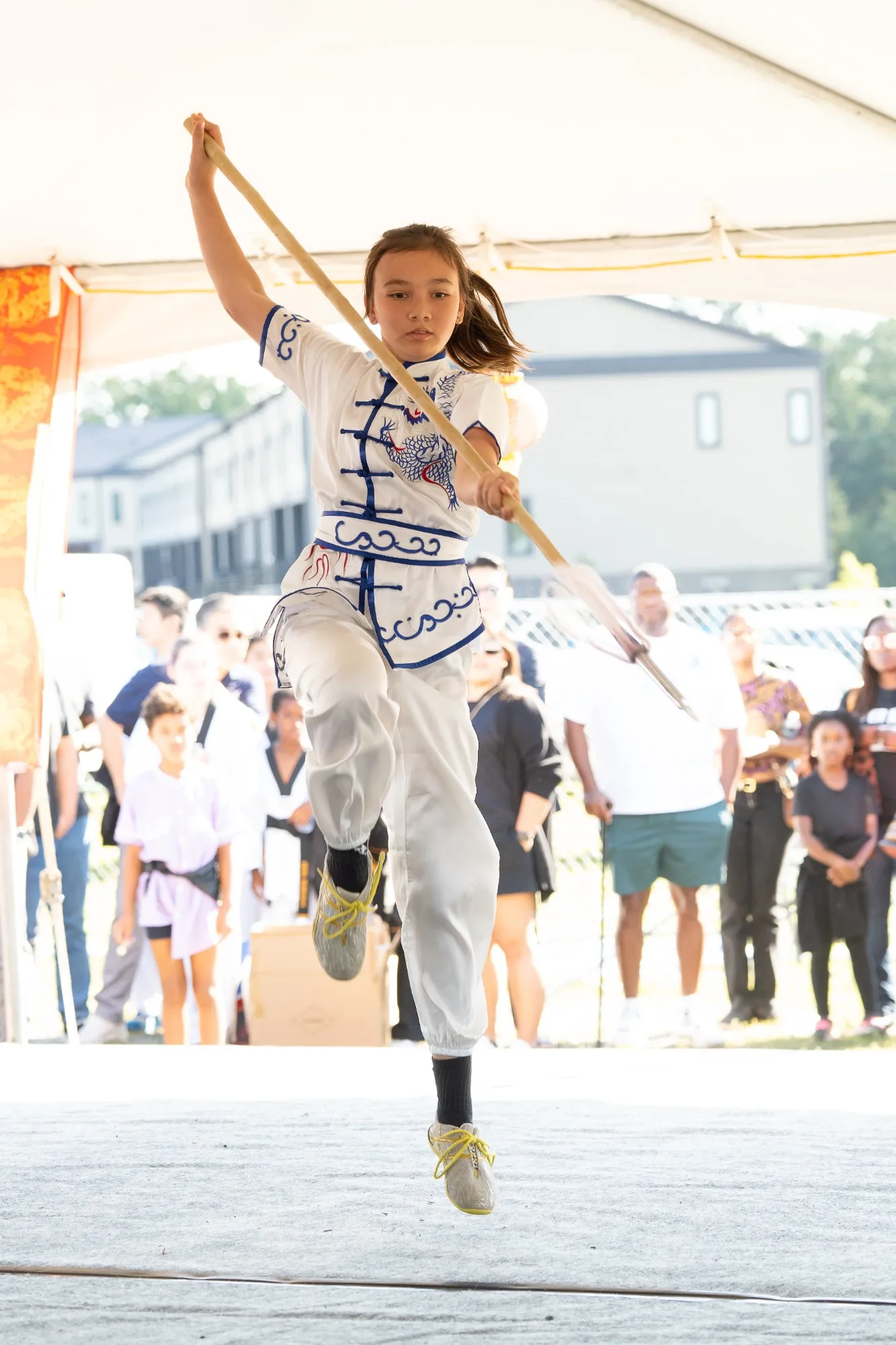 A young martial artist in a dragon-embroidered kung fu uniform performs a wushu spear routine at US Asian Fest